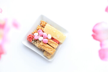 Chinese new year festival decorations. set of chinese sweetmeat made of nut,sesame and many ingredients on white background and plum flowers.top view 