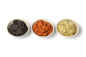 Bowls with fresh made Baba ganoush, Muhammara and black Hummus isolated on white background