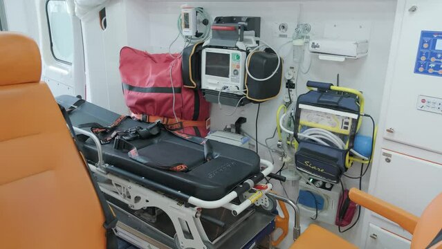 Inside the ambulance, view from the sanitary compartment. Different medical equipment and a stretcher.