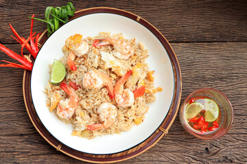 Shrimp fried rice. stir fried rice with shrimp decorate flowers from red chilly peppers, lime and fish sauce on table.Thai food style,Top view. 
