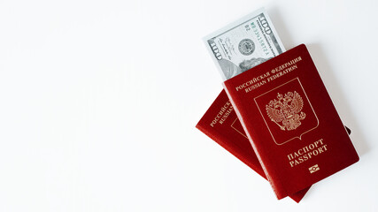 Top view two international passports of citizens of russian federation and money, one hundred dollar bills cash on white table, copy space