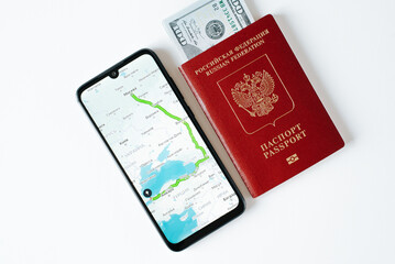 Online map app with geolocation and travel route on mobile phone, Russian international passport and money. Trip, journey, emigration, vacation concept. Close-up, top view