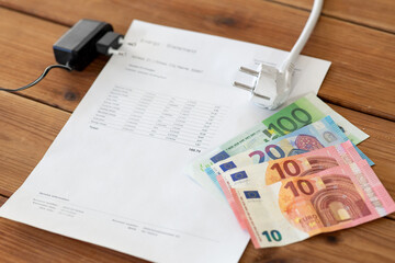 electricity, energy crisis and power consumption concept - close up of utility bill, money and...