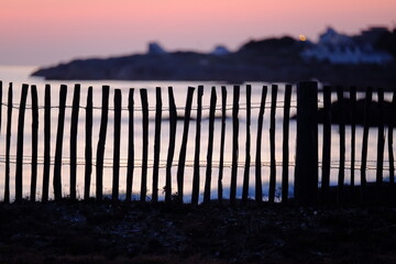 A small wooden fence at the Atlantic ocean.March 2022, Batz-sur-Mer, France.