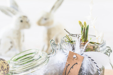 Mini hyacinth in mason jar decorated with feathers and easter bunny, spring or easter decoration