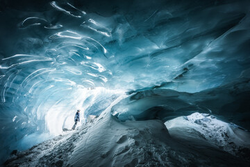 Silhouette of a person exploring a beautiful glacier ice cave