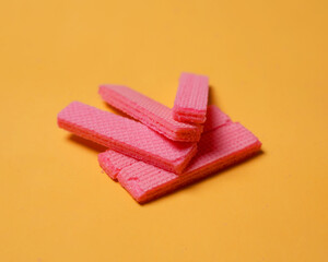 Stacks of pink wafers neatly arranged on a yellow background. Pile of taro flavored wafers. savory and crunchy snacks. snack. colorful wafers. food photography. delicious and delicious