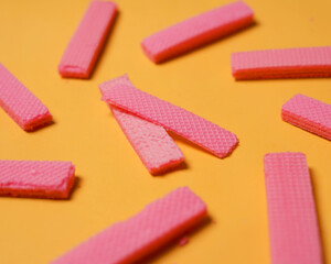 Stacks of pink wafers neatly arranged on a yellow background. Pile of taro flavored wafers. savory and crunchy snacks. snack. colorful wafers. food photography. delicious and delicious