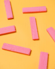 Stacks of pink wafers neatly arranged on a yellow background. Pile of taro flavored wafers. savory and crunchy snacks. snack. colorful wafers. food photography. delicious and delicious