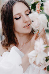  Portrait of a beautiful bride near the arch of white roses close-up. The concept of flowers and floristry