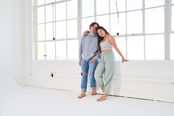 dancing couple leans on ledge of large window