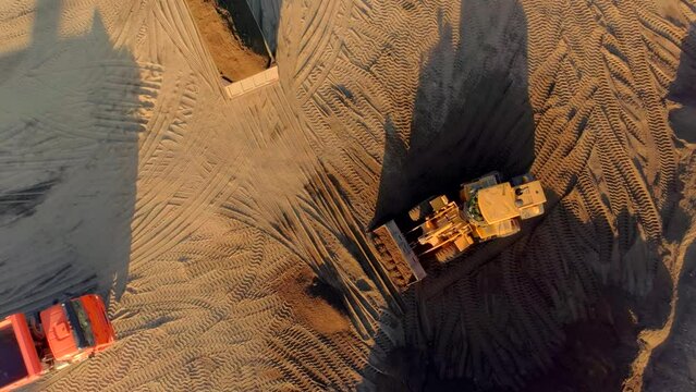 Bird's-eye view. Scene.Large trucks on an empty desert terrain reproduce construction work.