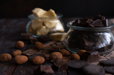 Pieces of raw choclate and cocao butter in glass jars.