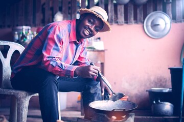 Smile Indigenous African man cooking in a rural kitchen