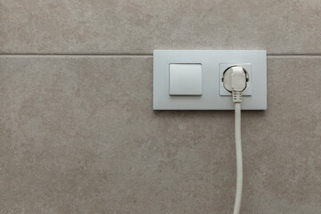 Electric extension cord plugged into wall outlet