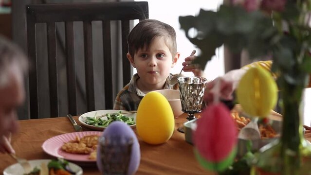 Little boy eating an ice cream at Easter dinner tabe at home