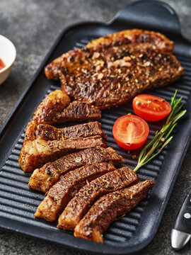 Grilled top sirloin or cup rump beef meat steak on black board. Dark background. Picanha steak