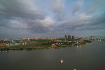 Obraz premium Aerial view of Bitexco Tower, buildings, roads, Thu Thiem 2 bridge and Saigon river in Ho Chi Minh city - Far away is Landmark 81 skyscrapper. This city is a popular tourist destination of Vietnam