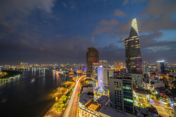 Aerial view of Bitexco Tower, buildings, roads, Thu Thiem 2 bridge and Saigon river in Ho Chi Minh city - Far away is Landmark 81 skyscrapper. This city is a popular tourist destination of Vietnam