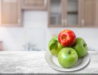 Green and red apple fruit in wooden basket on natural garden background.