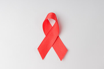 red ribbon symbol of the fight against cancer on a white background
