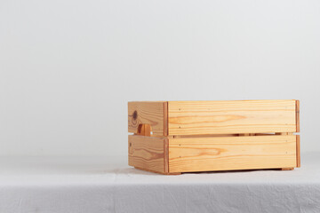 Empty wooden box on a table near white wall