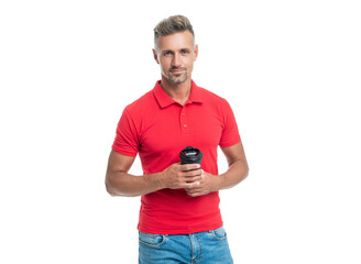 Serious guy in casual red tshirt holding takeaway coffee cup isolated on white