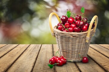 Naklejka na ściany i meble Fresh ripe cherries on a wooden table on natural background