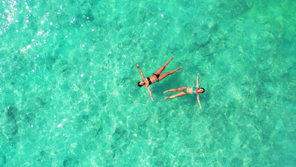 Aerial Shot girls swim in the turquoise, clear water of Gili Meno Island, Lombok, Indonesia. © Saowakhon Brown/Wirestock Creators