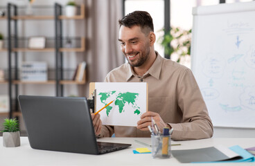 distant education, school and remote job concept - happy smiling male geography teacher with world map and laptop computer having online geography class at home office