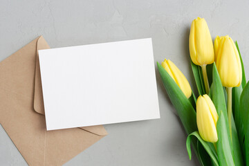 Greeting card mockup with envelope and yellow tulip flowers bouquet