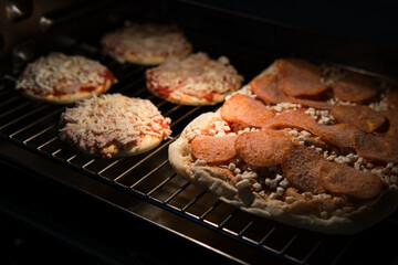 Frozen pizza semi-finished product with tomato sause and cheese on grill prepared for baking in oven. Selective focus