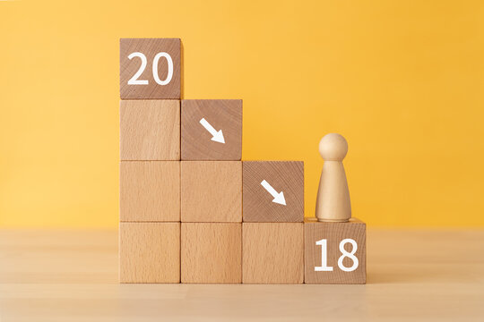 成人年齢引き下げのイメージ｜「20」「18」と書かれた積み木と人形