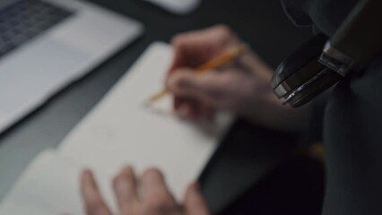 Man, graphic designer works remotely, sitting home chair living room. Pencil draws graphics on paper notebook, logo design UI design website icons application smartphone graphic image remote freelance - Powered by Adobe