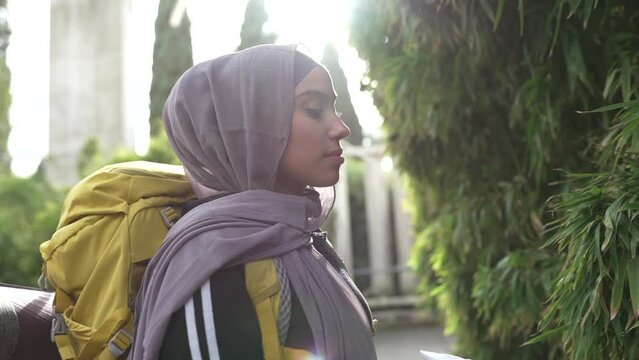 beautiful arabian woman with jihad, backpacker in nature touching plants, at sunset - travel concept -