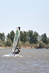 Naklejka premium Windsurfer on a windy summertime day at the lake.