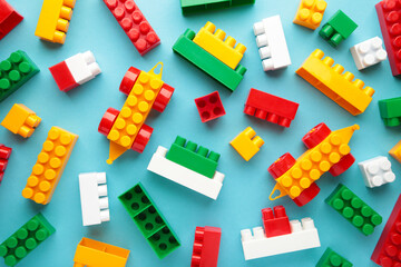 Multicolored blocks of the children's constructor lie on a blue background.