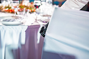 waiter puts the cover on the chair. Restaurant service. buffet or catering.