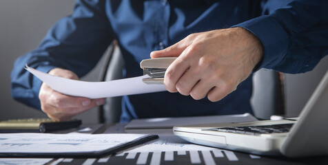 Man with a stapler connects the documents.