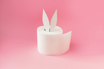Bunny ears out of white toilet paper roll on pastel pink background. Easter coronavirus trendy...