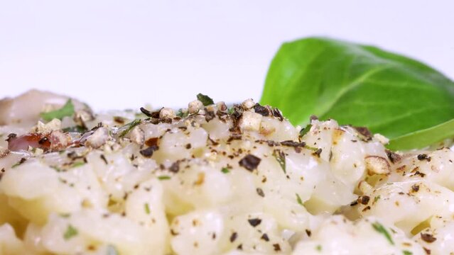 Close up view of homemade risotto covered with spices, macro shot in 4k, white background.