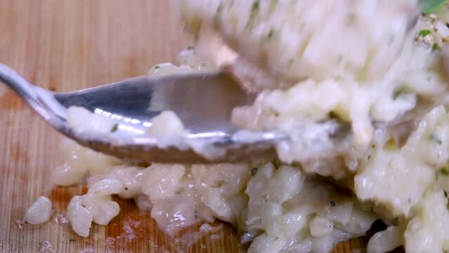 Taking some homemade risotto with a small spoon, macro shot in 4k.
