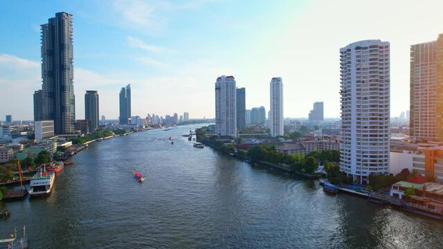 4K : Drones fly over the Chao Phraya River, buildings and business districts in Bangkok. Amazing sunrise drone footage. Aerial top cityscape view from drone
