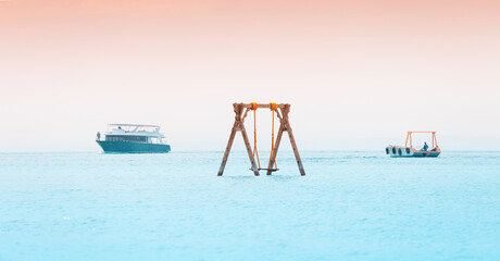 swing in the sea with cruise ships in the resort paradise spot