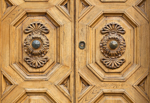 Detail of an old italian wooden door with floral decoration