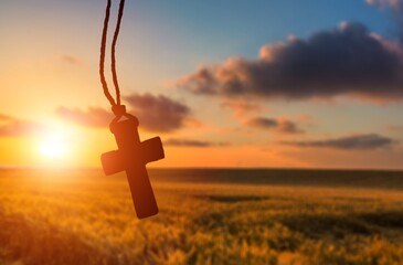A christian cross at a scenic sunset or sunrise