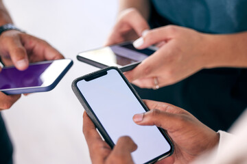 Its all about the connection. Shot of a group of business people using their smartphones together.