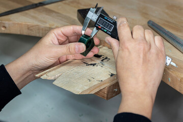 Female jeweler measuring the wax ring tube before sculpting and casting the metal ring.
