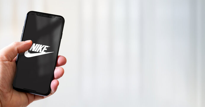 Hand holding iphone smartphone with Nike logo, Paris, France