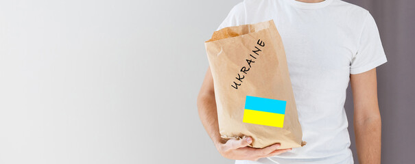 A man holds a box of aid for Ukrainian refugees and poor citizens who find themselves in a war...